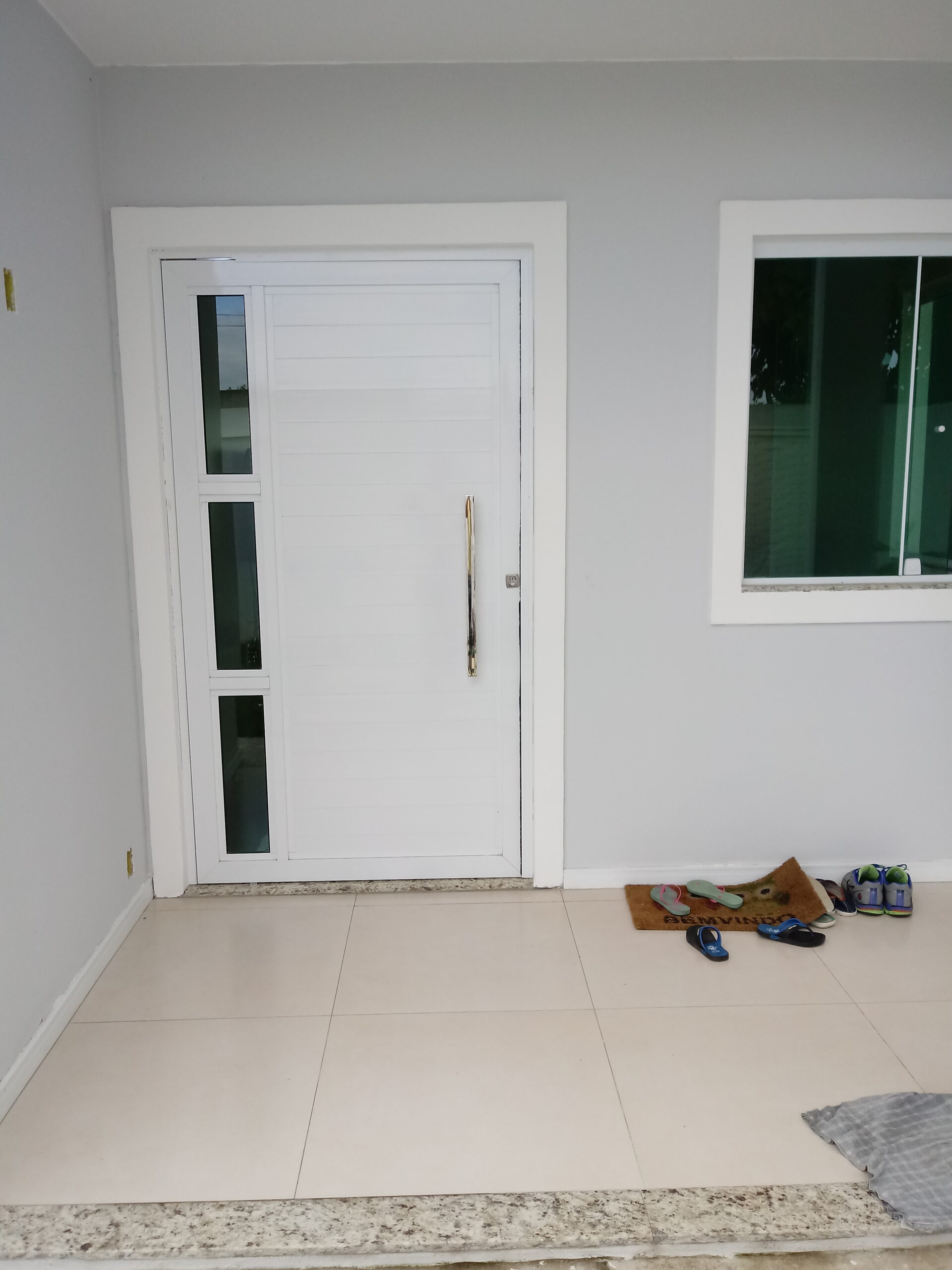 porta de alumínio branco com maçaneta reta